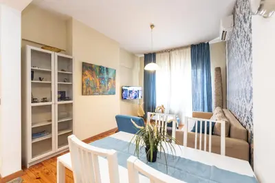a kitchen and living room with a table and chairs at Rentapart Step in Sofia