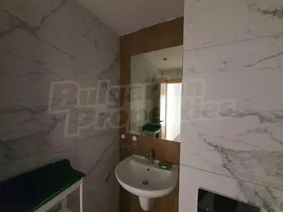 a bathroom with a sink and a mirror at Denitsa Apartment in Borovets
