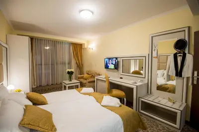 a hotel room with two beds and a television at Hotel Forum in Pazardzhik