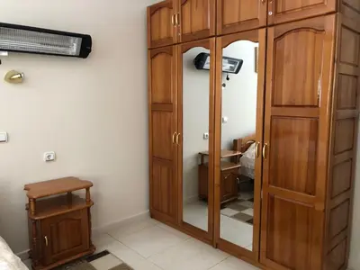 a wooden cabinet in a room with a bedroom at Manastira 2 apt Emo Pamporovo in Pamporovo