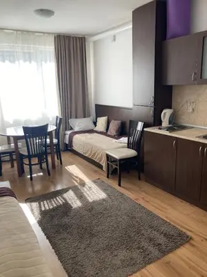 a living room with a bed and a table and chairs at Iglika 2 Ski Apartment in Borovets