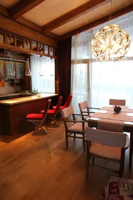 a dining room with a table and chairs and a chandelier at Villa Nataly at Golf Resort in Bansko