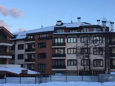 an apartment building with snow on top of it at Ramada 2 Boutique Apartment near Ski Road in Bansko