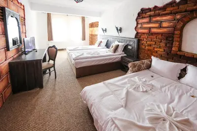 a hotel room with two beds and a desk and a bedroom at Royal Valentina Castle in Ognyanovo