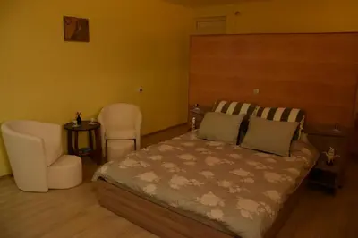 a bedroom with a bed and a chair at Lakeview-Estate ApartHotel in Staro Myasto