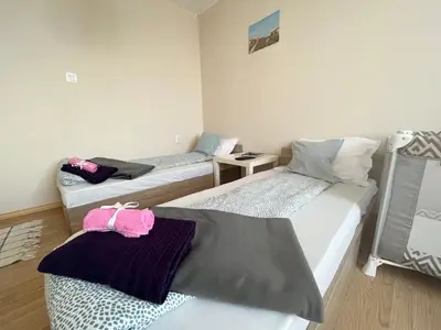 a room with two beds and a table at Airport Apartment in Sofia