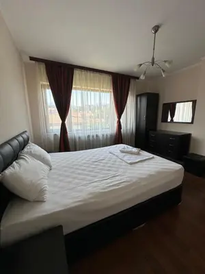 a bedroom with a large white bed in front of a window at Valevitsata Guesthouse in Razlog