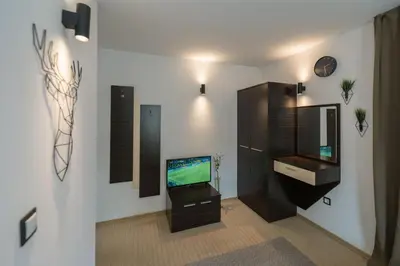 a living room with a television and a cabinet at Kadiyata Guest House in Bansko