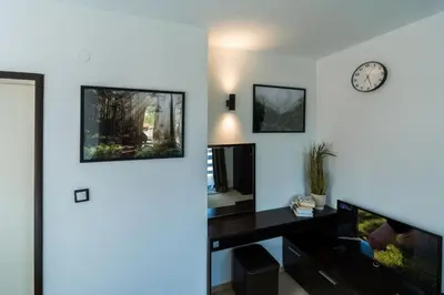 a room with a desk and a clock on the wall at Kadiyata Guest House in Bansko