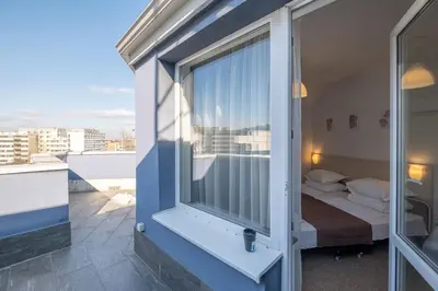 a room with a balcony with a bed and a window at Blue Label Apart House in Sofia
