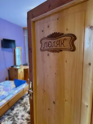 a wooden door with a sign on it in a bedroom at Mama Emiliya Guest House in Beli Iskar