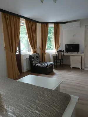 a living room with a bed and a television at Galaxy Hotel in Chiflik
