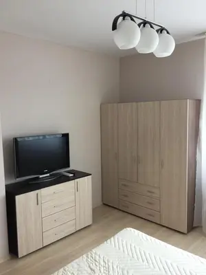a living room with a television and a wooden cabinet at PM Mountain View Fireside Retreat Bansko in Bansko