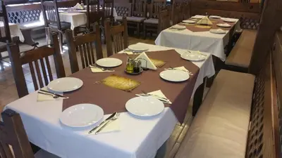 a dining room with tables with white plates and silverware at Hunting Residence Lodge in Panichishte