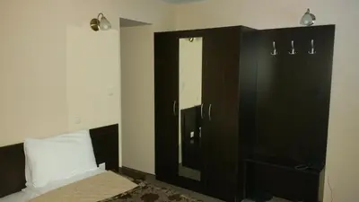 a bedroom with a bed and a cabinet with a mirror at Hunting Residence Lodge in Panichishte