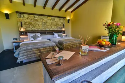 a bedroom with two beds and a table with fruit on it at Zornitza Family Estate Relais & Chateaux in Melnik
