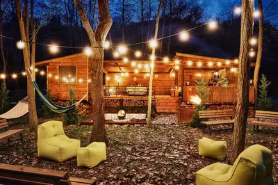 a log cabin with a hammock in the yard at night at Zornitza Family Estate Relais & Chateaux in Melnik