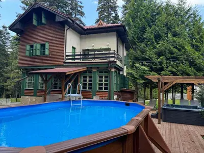 a house with a swimming pool in front of a house at Villa Adis with Hot Pool & Jacuzzi by BookVillaBG in Borovets