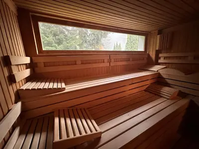 a wooden sauna with a window in the middle at Villa Adis with Hot Pool & Jacuzzi by BookVillaBG in Borovets