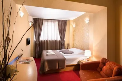 a hotel room with a bed and a couch at Hotel Central Point in Sofia