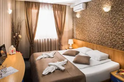a hotel room with a bed with towels on it at Hotel Central Point in Sofia