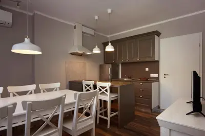 a kitchen and dining room with a table and chairs at Esterra Vini Guest House in Perushtitsa