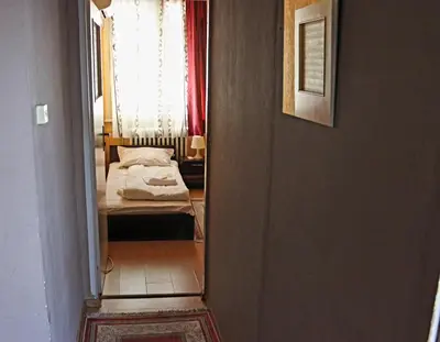 a hallway leading to a bedroom with a bed at Serdika Rooms in Sofia