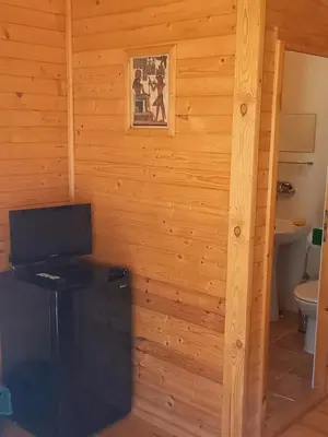 a room with a television in a wooden wall at Вилно селище МИРОВЕЦ in Malŭk Izvor