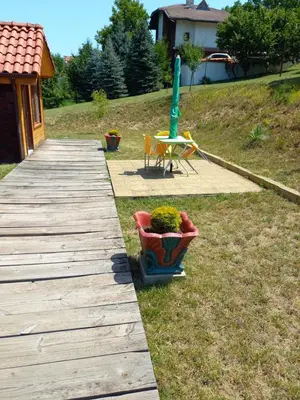 a wooden walkway with a potted plant and a table at Вилно селище МИРОВЕЦ in Malŭk Izvor