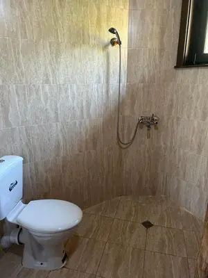 a bathroom with a toilet and a shower at Eco Village Under the Cliffs in Ilindentsi