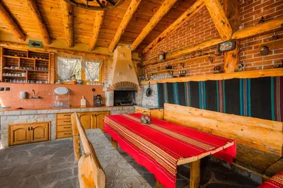 a dining room with a red table in a kitchen at Eco Village Under the Cliffs in Ilindentsi