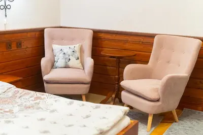 two chairs and a bed in a room at Grancharova Guest House in Bansko