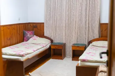 a small room with two beds and two tables at Grancharova Guest House in Bansko