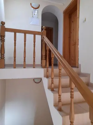 a staircase in a home with wooden railings at Yana Guest House in Dobrinishte