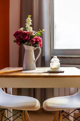 a vase of flowers on a table with two chairs at Apartment 11 in Sofia