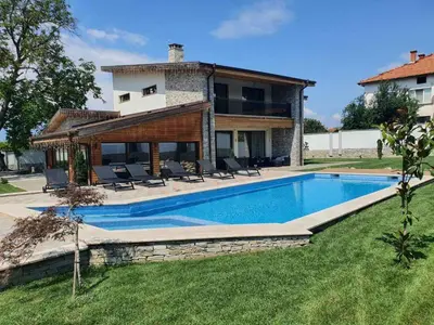 a villa with a swimming pool in front of a house at Vila Antik in Garmen