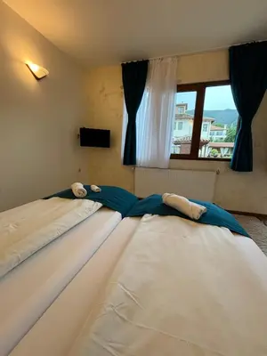 two beds in a room with a window at Вила Флора Паталеница in Patalenitsa