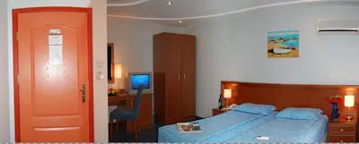 a bedroom with a bed and a desk and a television at Hotel Kibella in Sofia