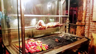 a piece of meat is cooking on a grill at Oksana's Apartment at Infinity in Bansko