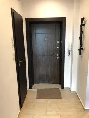 a hallway with a black door and a tile floor at Golden Dome view Apartment in Sofia