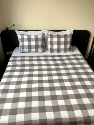 a bed with a checkered blanket and two pillows at Golden Dome view Apartment in Sofia