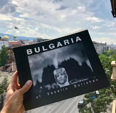 a person holding up a book about bulgaria at Golden Dome view Apartment in Sofia