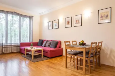 a living room with a red couch and a table at Spacious 2-Bedroom Apartment - Ideal for Families & Groups - City Center in Sofia