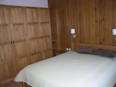 a bedroom with wooden walls and a bed with two pillows at LVV Pirin Golf Villa in Bansko