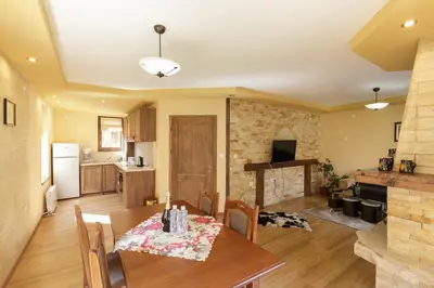 a kitchen and living room with a table and chairs at Rupchini Houses in Bansko
