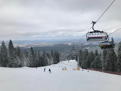 a ski lift with people skiing down a snow covered slope at Studio in Hotel Flora Borovets in Borovets