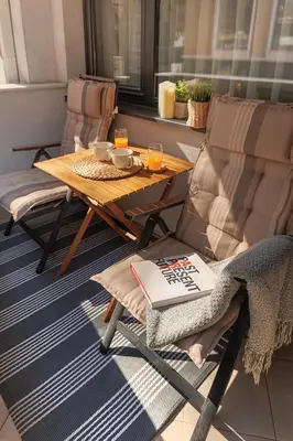 a table and chairs with a coffee table and a book at City Center Apartments with Parking in Plovdiv