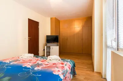 a bedroom with a bed with a blue comforter at Ibar Apartment & Garage in Plovdiv