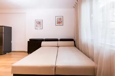 a bed in a room with a large window at Ibar Apartment & Garage in Plovdiv