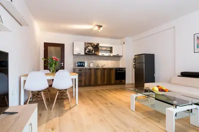 a kitchen and living room with a table and chairs at Ibar Apartment & Garage in Plovdiv